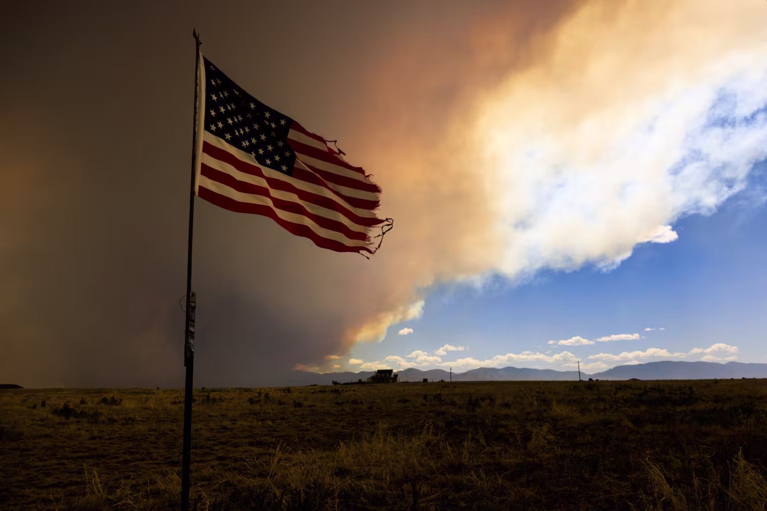 Smoke from the Aspen Acres fire rises above a home on July 1, 2026 in Pueblo, Colorado. Over 35,000 acres and more than 100 structures have burned in the Aspen Acres fire, one of several blazes that are currently burning across the state after a warm and dry winter.