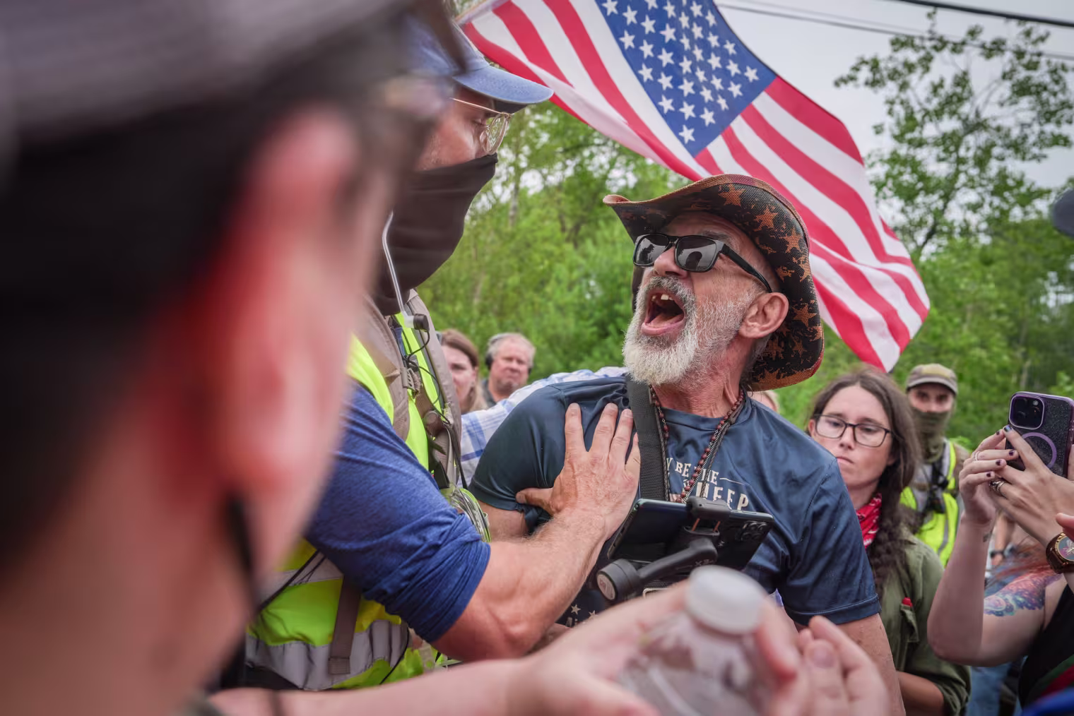 An ICE supporter is held back by an anti-ICE protester at a demonstration on July 14, 2026, after a man was fatally shot by ICE agents in Scarborough, Maine.