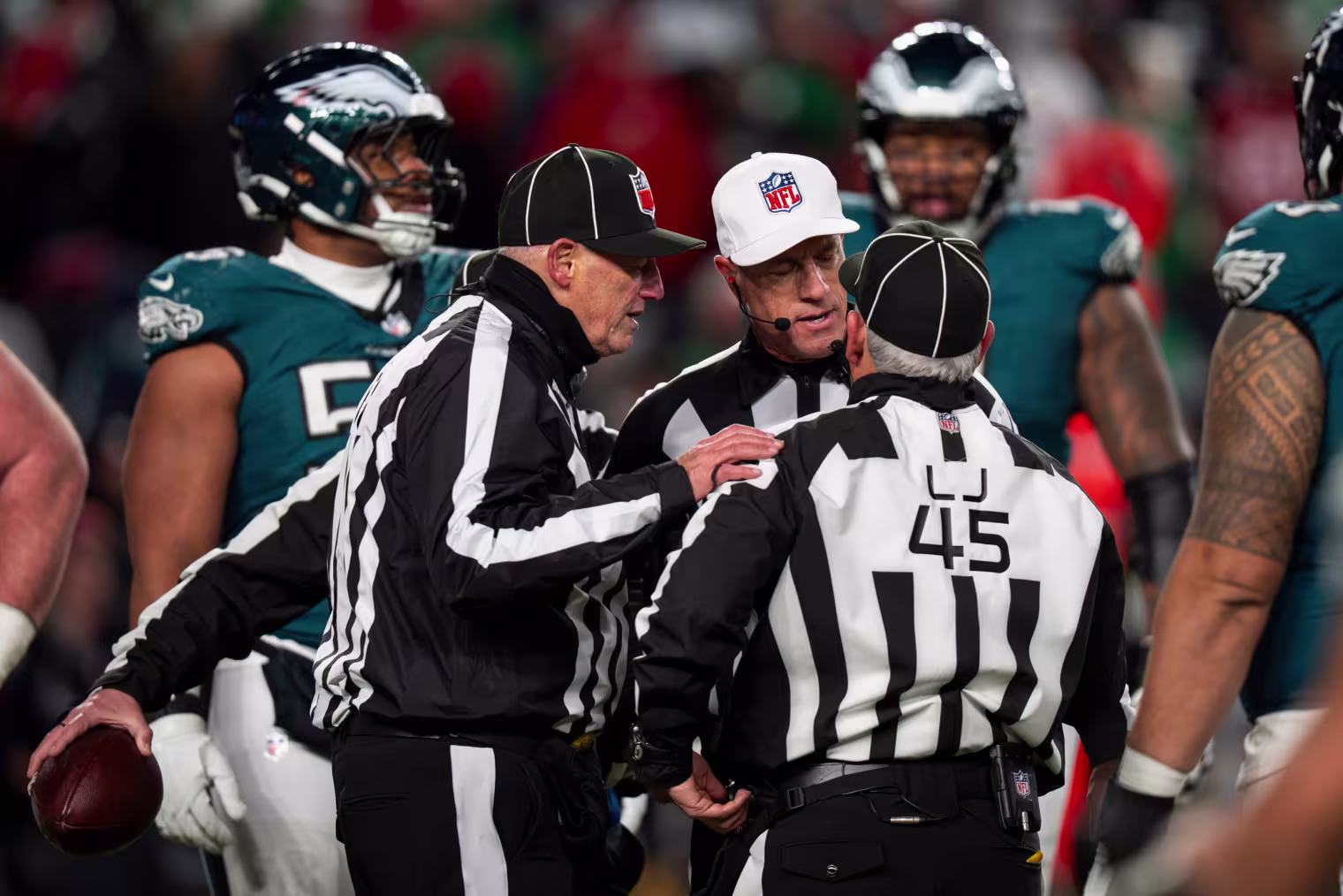 Referee Alan Eck, center, and umpire Paul King, left, talks things over with line judge Jeff Seeman, right.