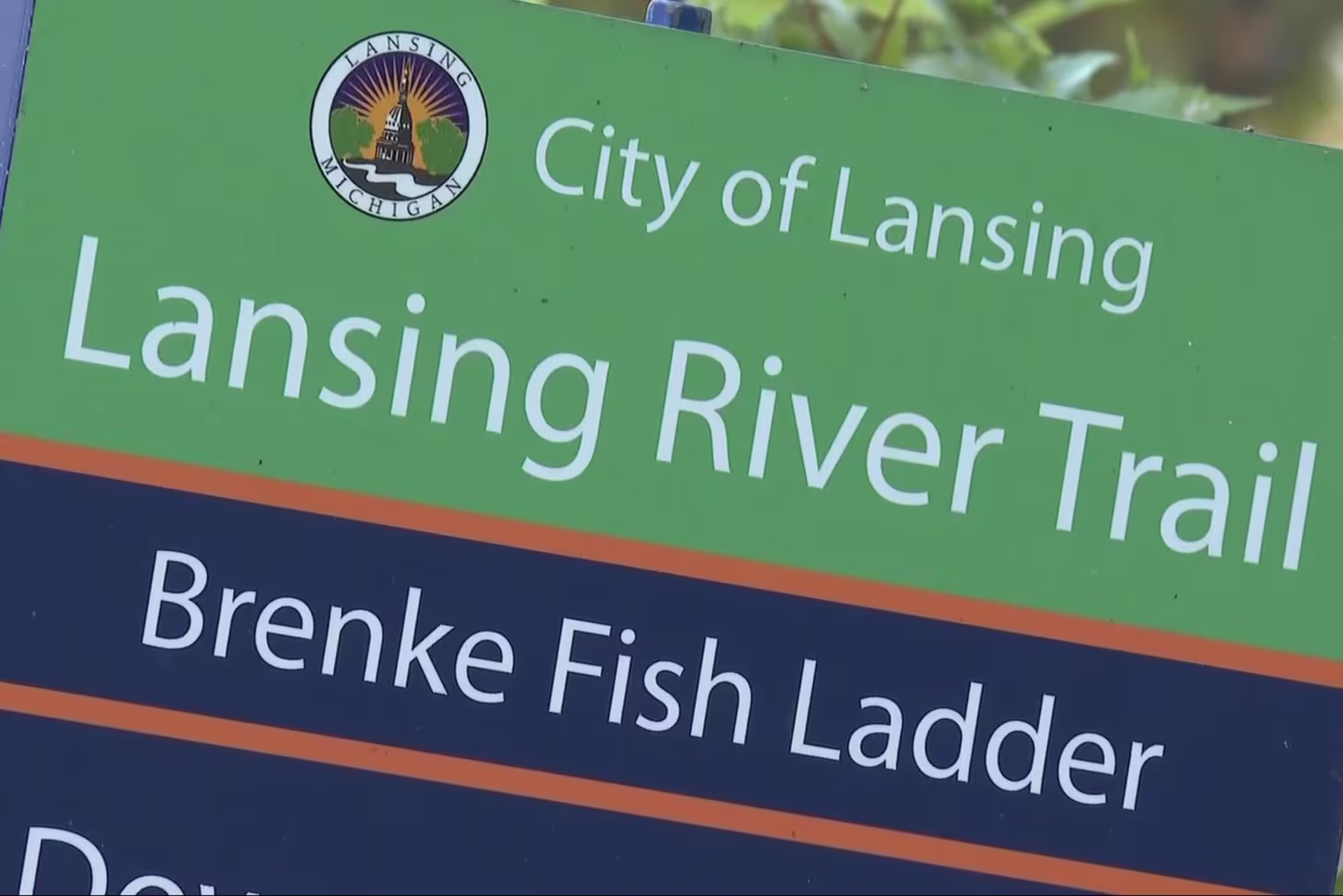 A ssign that reads "City of Lansing, Lansing River Trail, Brenke Fish Ladder"