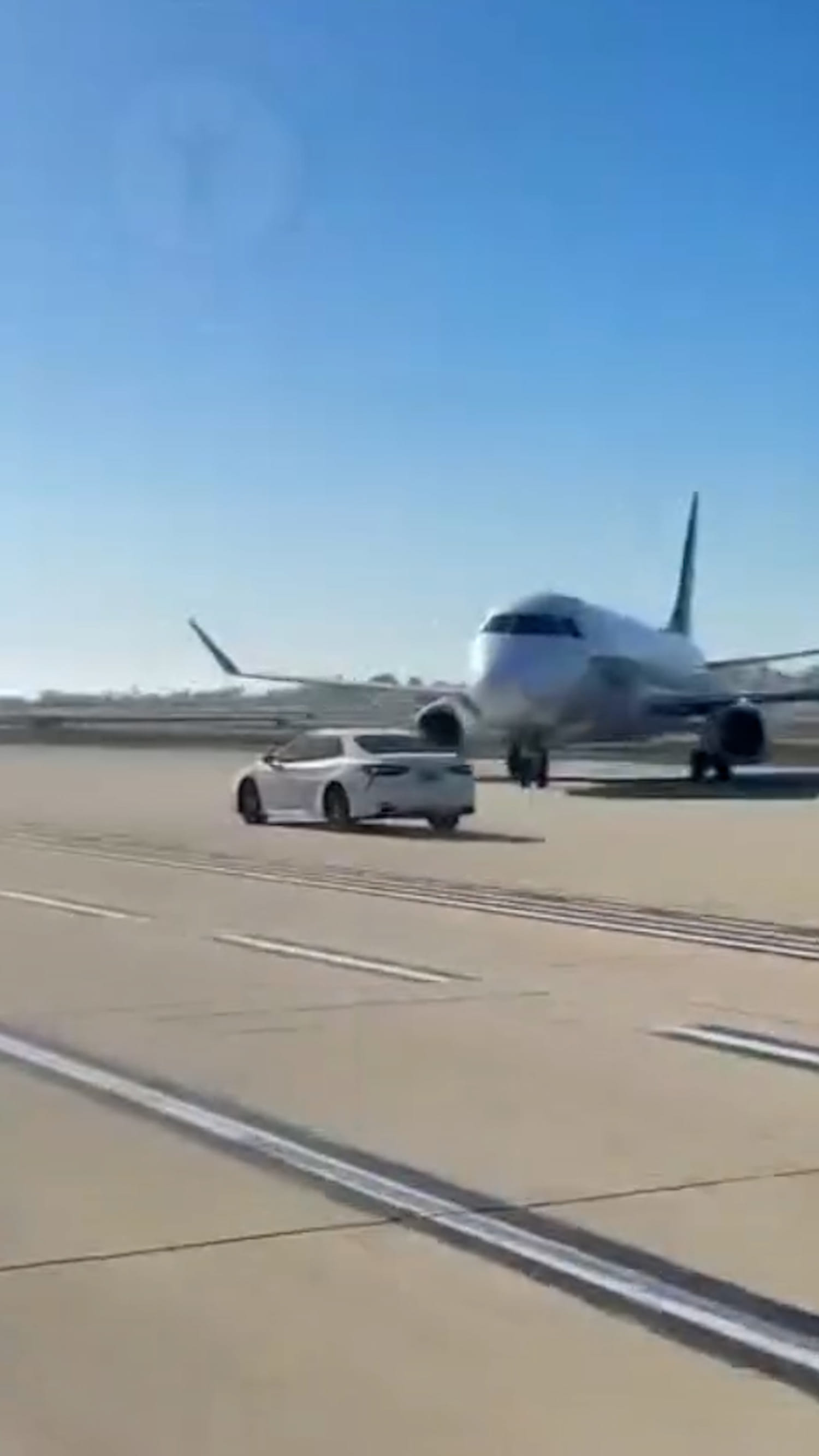 Car speeds down the taxiway at John Wayne Airport