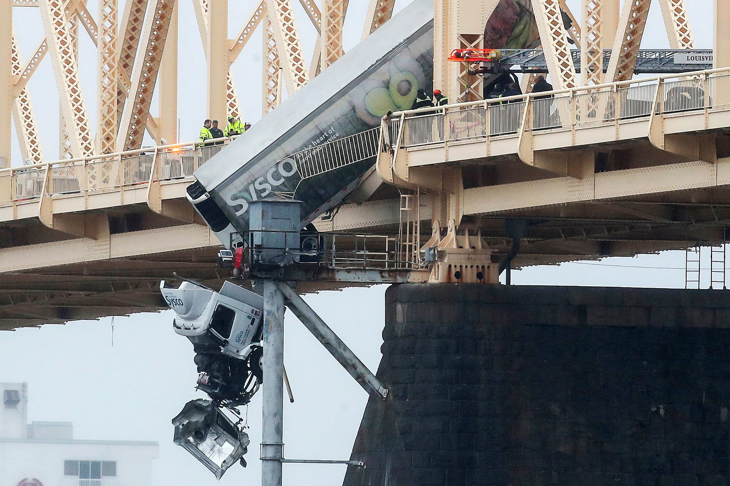 Truck driver pulled to safety after crash leaves vehicle dangling over bridge across Ohio River