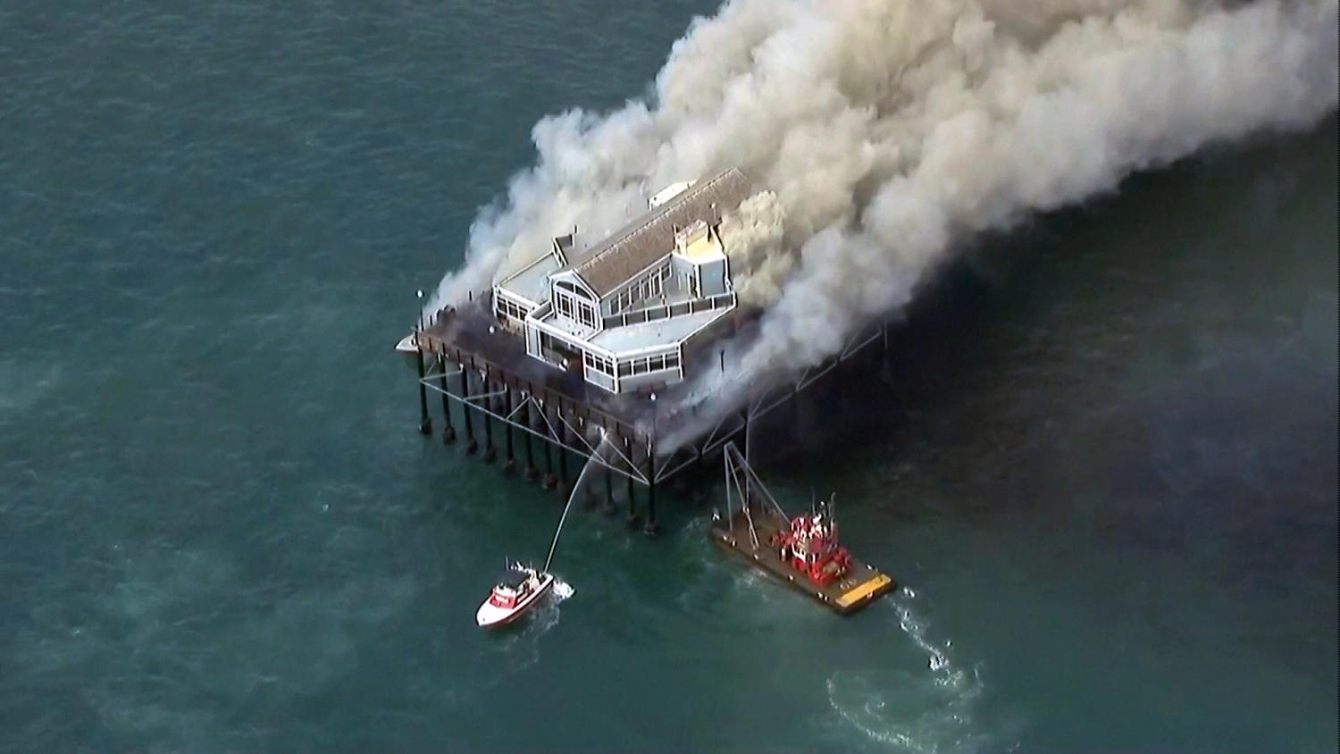 Building at end of Southern California pier catches fire, sending smoke billowing onto beach