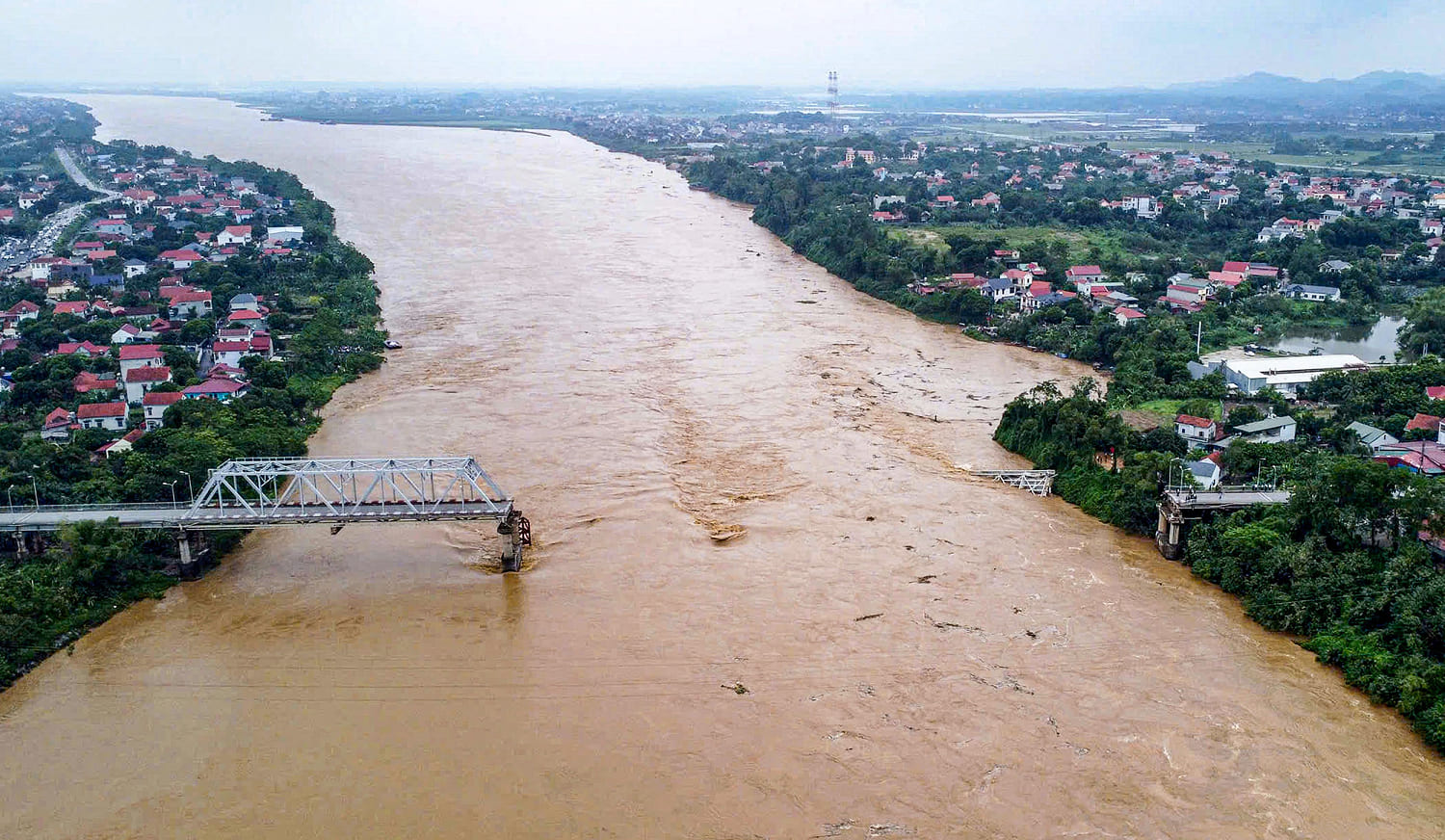 Flooding sweeps away a bus and a bridge collapses in Vietnam as storm deaths rise to 59