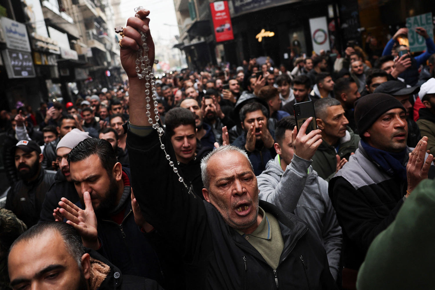 Hundreds protest in Damascus after hooded figures set Christmas tree ablaze