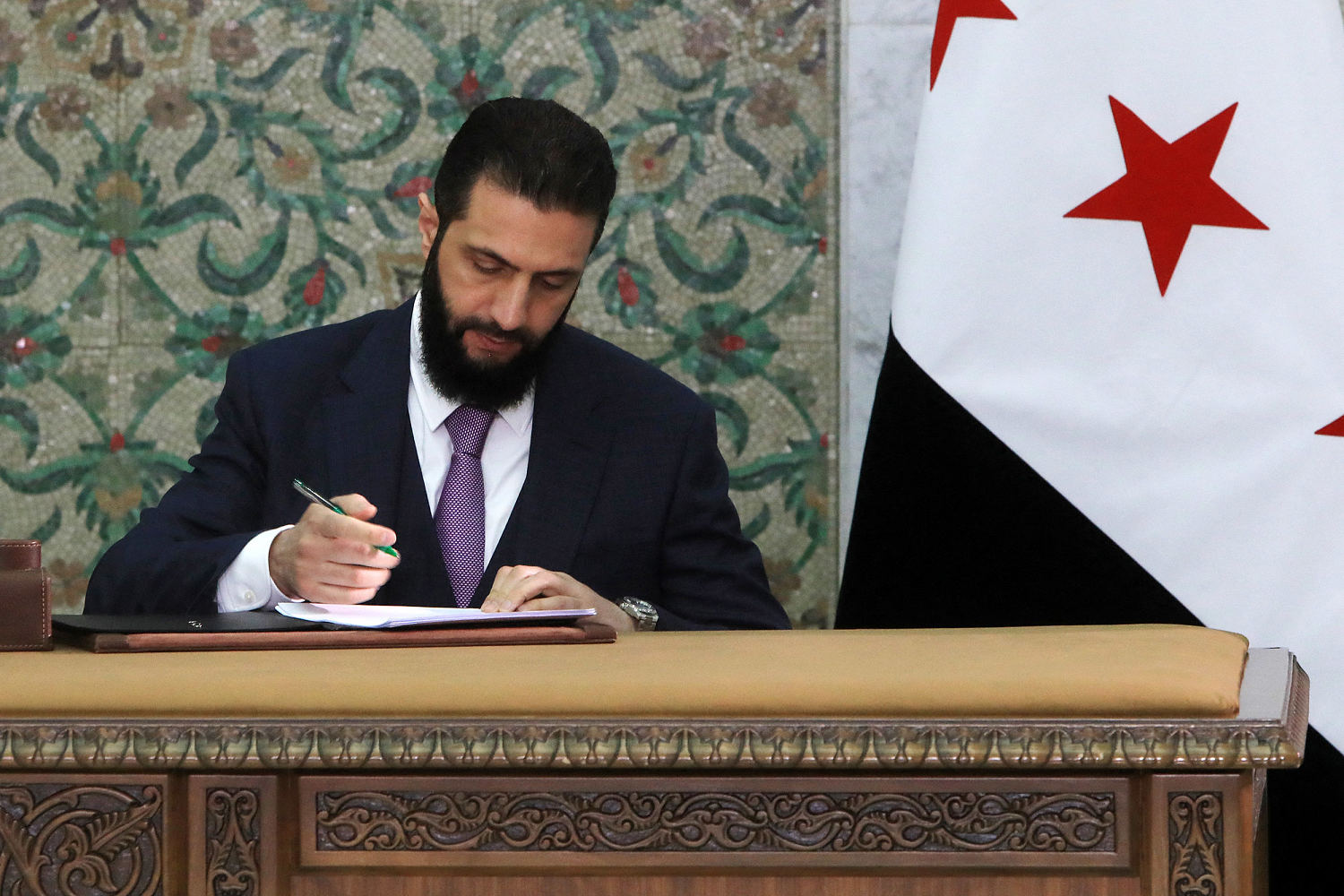 Syria's new leader signs constitution to keep his Islamist group in power for five years