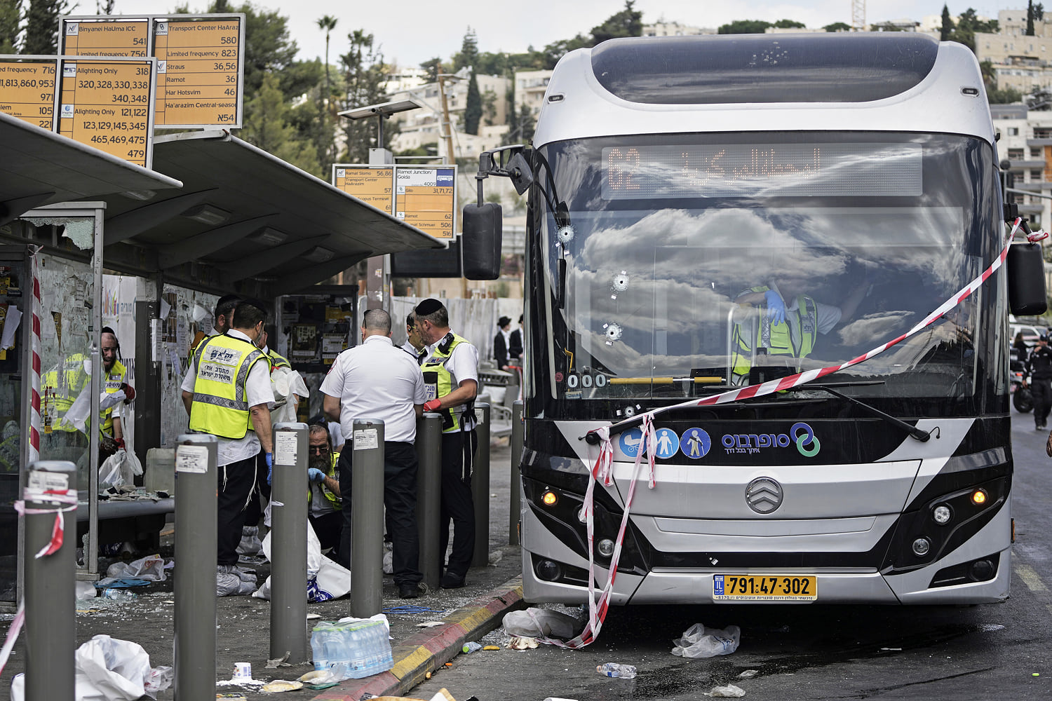 Gunmen kill six and critically injure seven at a Jerusalem bus stop