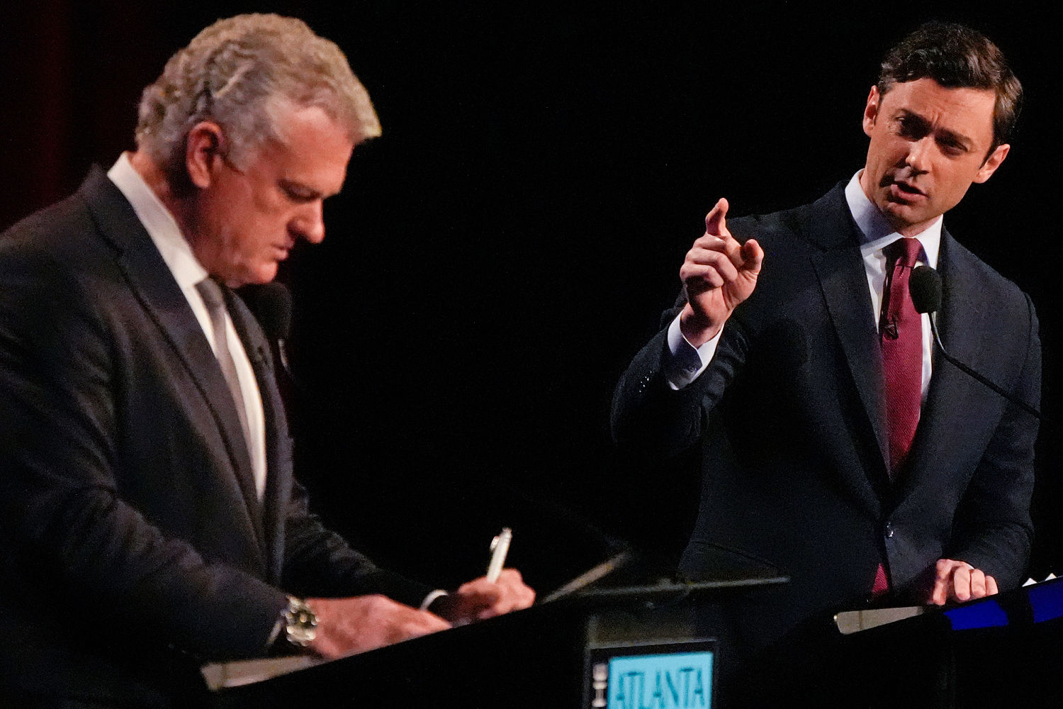Rep. Mike Collins listens to Sen. Jon Ossoff during a debate Tuesday.
