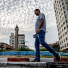 A man takes an early morning walk with a cup of coffee along a street in Gaza City on Oct. 3, 2023. 