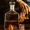 a photo of a whiskey decanter with a caramel colored whiskey in it