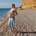 a pregnant woman standing on the seashore