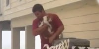 Man rescues cat from atop an air conditioner during Hurricane Ian