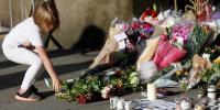 Image: A girl leaves flowers for the victims of an attack on concert goers at Manchester Arena, in central Manchester