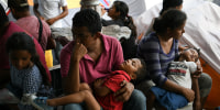 Image: Honduran asylum seekers sent back to Mexico from the U.S. under Migrant Protection Protocols (MPP) pass the time at a makeshift encampment in Matamoros