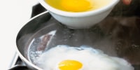Eggs being poached in frying pan