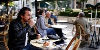 Image: A customer enjoys a coffee on a terrace of the cafe and restaurant Les Deux Magots in Paris as cafes, bars and restaurants reopen after closing down for months amid the Covid-19 outbreak in France