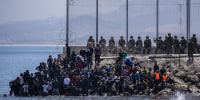 Image: Migrants wait to cross into the Spanish enclave of Ceuta, near the border of Morocco and Spain,