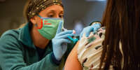 A medical worker administers a Johnson and Johnson Covid-19 vaccination at a FEMA-run mobile vaccination clinic at Biddeford High School in Biddeford, Maine, on April 26, 2021.