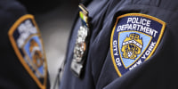 New York Police Department officers stand outside of a midtown Manhattan office building after evacuating workers that had been overcome by fumes in New York