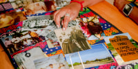 Historical photos displayed on a table including in the center a black and white photo of Corina Torralba Harrington's great grandmother, Effie Payne, whose Mexican name was Felipa Valdes, with her son, Ned Griner, whose Mexican name was Manuel Torralba, in Brackettville, Texas. Bottom right, is a photo of painted rock that marks the direction to Nacimiento de los Negros, Mexico where Juneteenth brings together descendants of Black Seminoles.