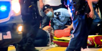 A police officer receives medical treatment after being stabbed in Hong Kong on July 1, 2021.
