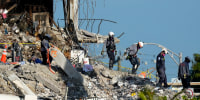 Image: Search and rescue workers descend from the rubble pile at the Champlain Towers South condo building, where scores of people remain missing one week after it partially collapsed on July 2, 2021, in Surfside, Fla.