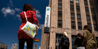 Image: People cross the street in front of the Twitter Inc. headquarters in San Francisco on June 9, 2021.