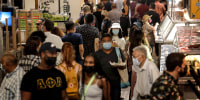 People, many masked, look for lunch at the Grand Central Market in downtown Los Angeles on June 15, 2021.