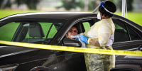 Image: Medical personnel conduct Covid-19 testing at a \"drive-through\" site in Miami, on August 3, 2021.