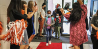 Sycamore Elementary students in Sugar Hill, Ga., walk down a red carpet laid out for them on their first day of school on Aug. 4, 2021.