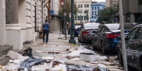 Image: A person walks past debris on the sidewalk after Hurricane Ida passed through on August 30, 2021 in New Orleans.