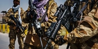 Taliban fighters armed with American weapons and equipment patrol and secure the outer perimeter alongside the American controlled side of of the Hamid Karzai International Airport in Kabul on Aug. 29, 2021.