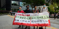 Pro-democracy activists outside a court in Hong Kong, Wednesday, Sept. 15, 2021, where nine people were handed jail sentences of up to 10 months over their roles in last year's banned Tiananmen candlelight vigil. The banner reads "Peaceful assembly is a human right, mourning the victims of June 4th is a conscience." (AP Photo/Kin Cheung)