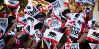 Supporters of California Gov. Gavin Newsom wave signs and California flags while waiting for the arrival of the governor and President Joe Biden at a rally on Sept. 13, 2021, in Long Beach.