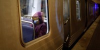 Image: A passenger wears a mask while aboard a Washington Metro Rail Car in Washington