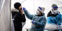 Image: A woman is tested for Covid-19 at a free testing site in Farragut Square in downtown on Jan. 10, 2022 in Washington, DC