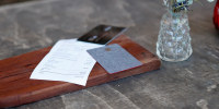 Close-up of credit cards and bill on table in rustic restaurant