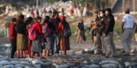 Image: Mexican immigration agents review the IDs of Guatemalan travelers at an access point to the Suchiate River, on the border between Guatemala and Mexico, near Ciudad Hidalgo, Mexico.