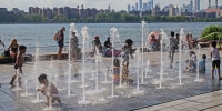 Children play in a water fountain in Brooklyn, N.Y., on June 30, 2021.