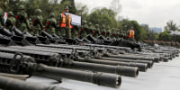 Mexican soldiers stand guard next to weapons seized from alleged drug traffickers or handed in by residents before they are destroyed at a military zone in Mexico City