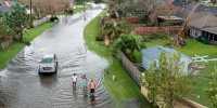 Image: People walk along a flooded street in the Spring Meadow subdivision in LaPlace, La., after Hurricane Ida moved through Monday, Aug. 30, 2021. Hard-hit LaPlace is squeezed between the Mississippi River and Lake Pontchartrain.