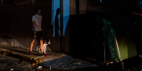 Image: A man walks his dog in a street left in darkness by a power outage due to a cyberattack in Old San Juan, Puerto Rico, on June 10, 2021.