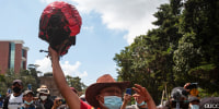 A demonstrator holds a head torn off from the statue of former President Jose Maria Reina Barrios during protests against the treatment of indigenous people by European conquerors during Hispanic Heritage Day in Guatemala City, Guatemala, on Oct. 12, 2021.