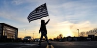 A demonstrator holding a Black Lives Matter flag