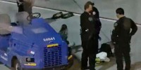 A woman who appears to have her hands cuffed behind her back sits on the tarmac after attempting to flag down a plane at Los Angeles International Airport.