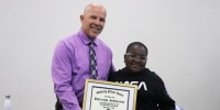 Davyon Johnson receives an honor from the Muskogee Police Department for using the Heimlich maneuver to save a classmate and later helping a woman with a walker get away from a housefire.