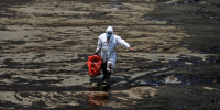 Image: Workers clean up an oil spill in Ventanilla