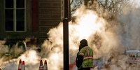 A construction worker stands near steam on a cold day in Washington, D.C., on Jan. 26, 2022.
