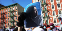 A person holds a photo of Christina Yuna Lee as people gather for a rally protesting violence against Asian-Americans in Chinatown, N.Y., on Feb. 14, 2022.