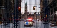 A police car is seen behind a barrier in front of Parliament Hill after police cleared Wellington Street, previously occupied by the Freedom Convoy, in Ottawa, on February 19, 2022.